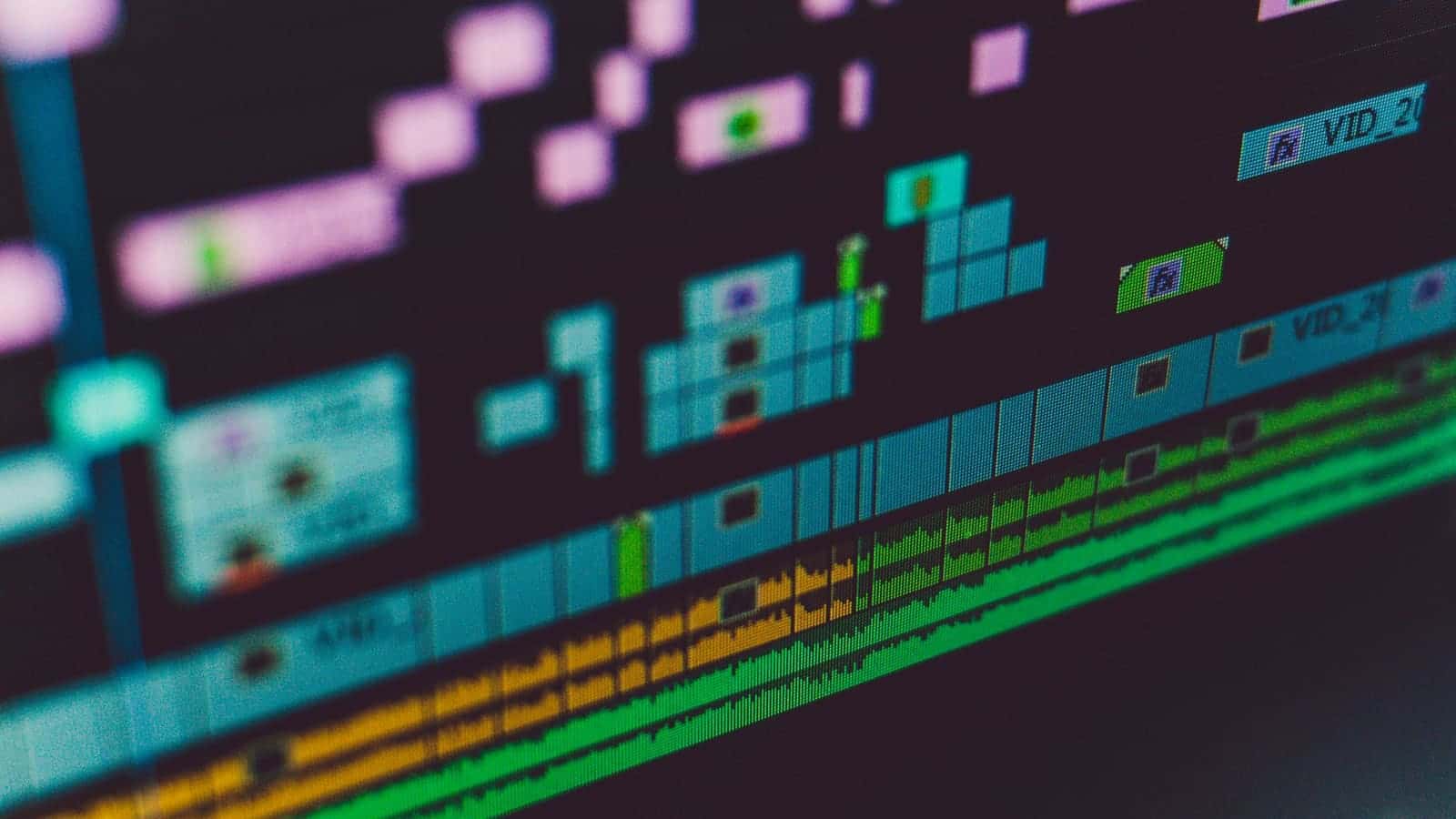 A video editing timeline with coloured clips and audio tracks on a screen